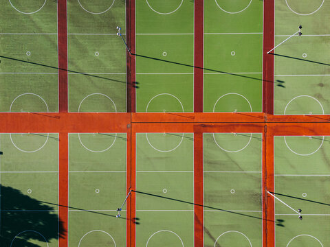 Aerial view of multiple green netball courts with white markings and red borders under bright sunlight in Devonport, Tasmania, Australia.