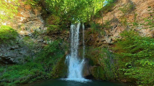 Waterfall cascades down rocky cliff face. Veliki Buk, Serbia.