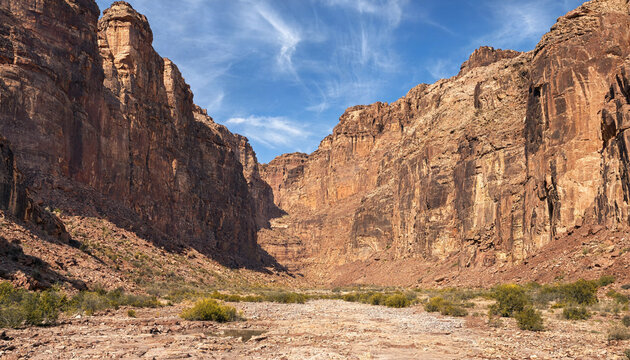 Vast desert canyon gorge between high rocky cliffs with landscape wilderness outdoors formation sandstone daylight sunlight dramatic geological national adventure textures climbing