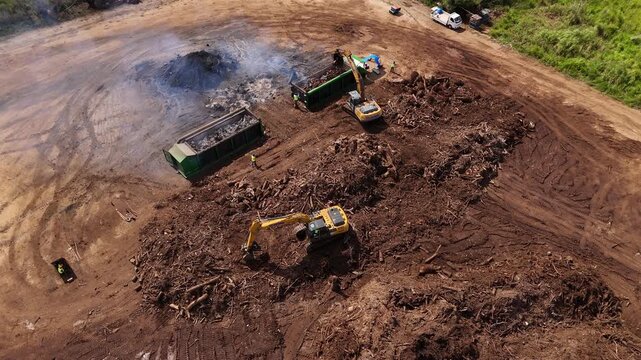 Tinian, Northern Mariana Islands - 26 June 2026: Aerial view of excavators working at a construction site with dumpsters and piles of earth.
