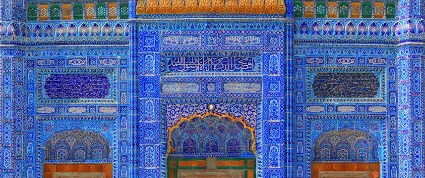 View of the intricate blue tile work on the facade of the Kamaro Sharif Mosque, featuring detailed geometric patterns and Arabic calligraphy in Kaamaro Sharif, Sindh, Pakistan.