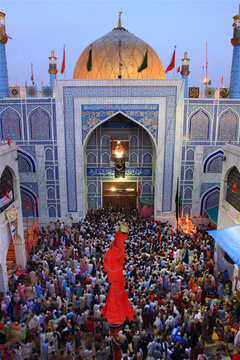 View of the ornate blue-tiled entrance of the Sehwan Sharif shrine filled with a large crowd of pilgrims during the annual Urs festival in Sehwan, Sindh, Pakistan.