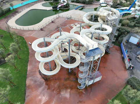 Seignosse, France - 23 September 2023: Aerial view of Seignosse Atlantic Park featuring winding water slides, pools, and surrounding greenery in a quiet park setting.