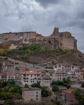 Aerial view of the medieval hilltop town of Frias with its historic castle, stone houses, and winding streets under a cloudy sky in Frias, Castilla y Leon, Spain.