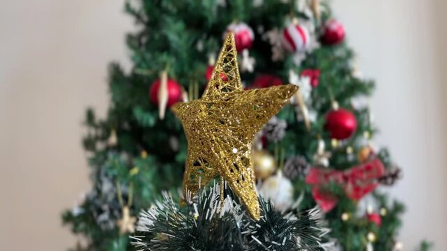 Estrella navide&ntilde;a girando con &aacute;rbol desenfocado