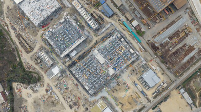Aerial view of Bridge Data Center under construction with large industrial buildings, cranes, and site development in Khlong Tamru, Chon Buri, Thailand.