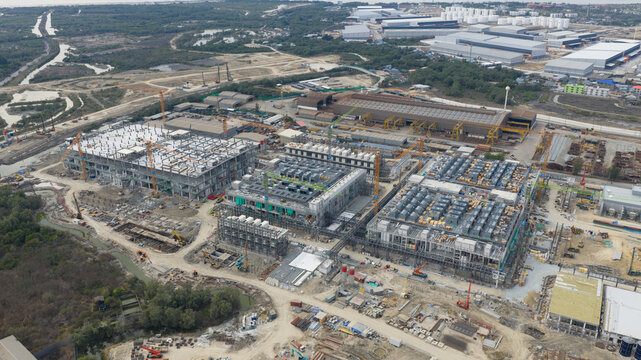 Aerial view of Bridge Data Center construction site featuring multiple industrial buildings, cranes, and warehouses in Khlong Tamru, Chon Buri, Thailand.