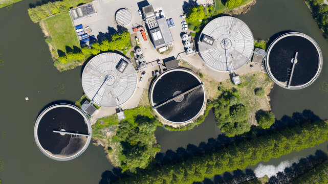 Aerial view of the RWZI Leidsche Rijn wastewater treatment plant featuring circular sedimentation tanks surrounded by lush greenery and water in Utrecht, Utrecht, Netherlands.