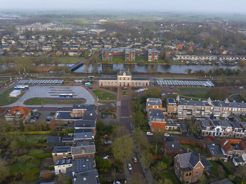 Aerial view of the railway station surrounded by residential buildings, a bus terminal, and a canal in Sneek, Friesland, Netherlands.