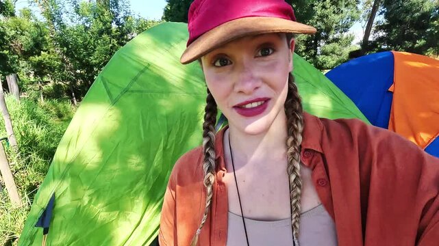 Happy woman, camping and influencer with tent for vlogging, travel or showing outdoor crib in nature. Portrait of female person or vlogger with smile for tour of sleeping bag or pov in countryside