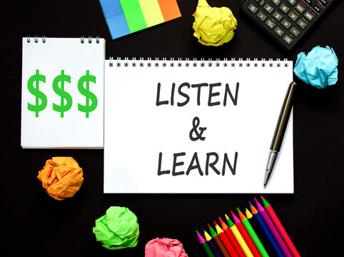 Listen and learn words symbol. Concept words Listen and learn on beautiful white note. Beautiful black background. Black pen. Black calculator. Business listen and learn support concept. Copy space.