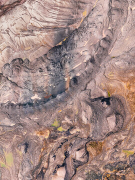 Aerial view of an open-pit coal mine showing deep excavation, layered earth, textured soil, and industrial terrain in North Rhine-Westphalia, Germany.