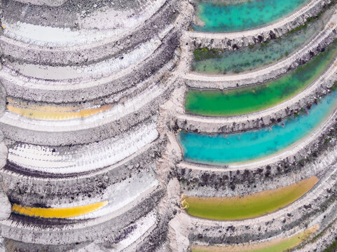 Aerial view of terraced mining site with colorful water pools in North Rhine-Westphalia, Germany.