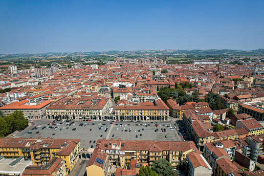 Aerial view of the historic Piazza della Liberta surrounded by traditional terracotta rooftops and urban architecture in Alessandria, Piedmont, Italy.