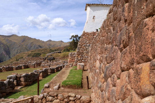View of the ancient Inca stone walls at the Chinchero archaeological site with mountains in the background in Cusco, Cusco, Peru.