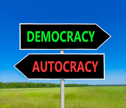 Democracy or autocracy words symbol. Concept words Democracy Autocracy on beautiful black road sign. Beautiful blue sky background. Business democracy autocracy concept. Copy space