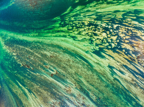 Aerial view of Lake Constance showing intricate patterns of sediment and clear turquoise water in Thurgau, Switzerland.