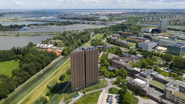 Aerial view of the Digital Realty Amsterdam AMS17 data center building surrounded by green spaces, canals, and modern office architecture in Amsterdam, Noord-Holland, Netherlands.