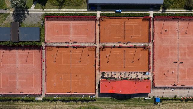 Aerial view of Tennisclub IJburg with multiple clay tennis courts, players on the courts, and surrounding greenery in Amsterdam, Noord-Holland, Netherlands.