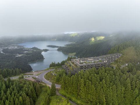 Aerial view of the abandoned Monte Palace Hotel overlooking the twin volcanic lakes of Sete Cidades surrounded by lush green forests in Sete Cidades, Azores, Portugal.