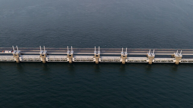 Aerial view of the Eastern Scheldt Storm Surge Barrier with its massive concrete piers and steel gates spanning the water in Vrouwenpolder, Zeeland, Netherlands.