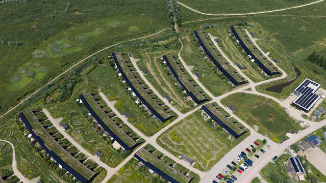 Aerial view of sustainable housing development with green roofs and solar panels integrated into the landscape in Almere, Flevoland, Netherlands.