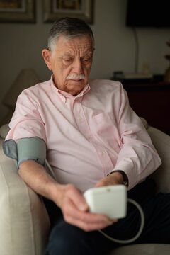 Senior man measuring blood pressure at home