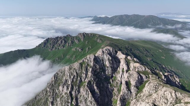4K UHD Drone Flight Above Dramatic Rocky Mountain Ridge and Sea of Clouds.