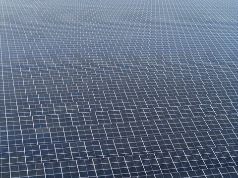 Aerial view of a large solar farm with rows of photovoltaic panels in Poland.