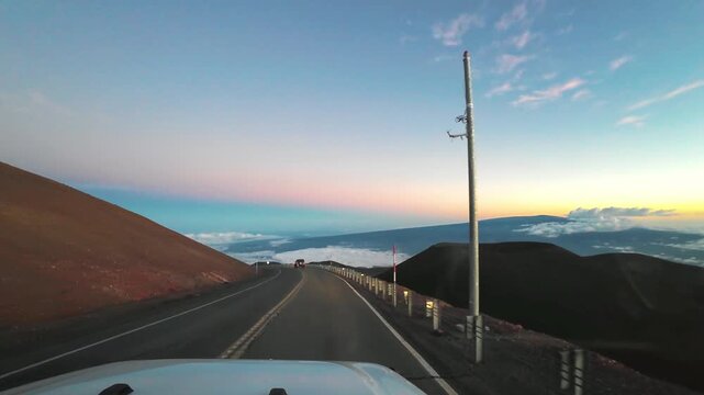 Road Trip Driving on Mauna Kea Summit Road at Sunset, Above the Clouds, Big Island, Hawaii, USA