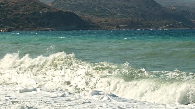 Beautiful view of storm waves rolling across sea against mountainous coastline. Crete. Greece.
