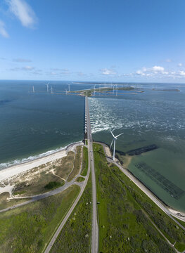 Aerial view of the Eastern Scheldt Storm Surge Barrier with wind turbines, road, and sea in Vrouwenpolder, Zeeland, Netherlands.