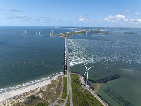 Aerial view of the Eastern Scheldt Storm Surge Barrier with wind turbines and coastal landscape in Vrouwenpolder, Zeeland, Netherlands.