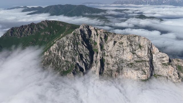 4K UHD Drone Flight Above Dramatic Rocky Mountain Ridge and Sea of Clouds.