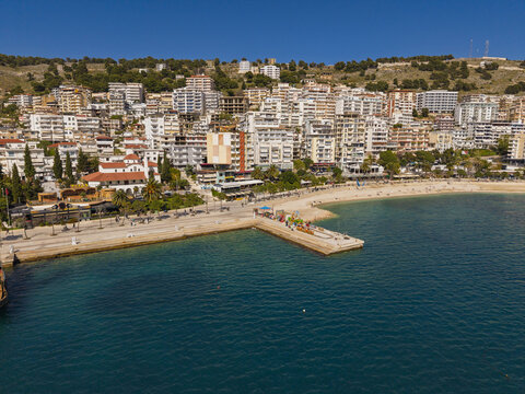 Aerial view of the coastal town of Saranda with its waterfront promenade, pier, and buildings along the Ionian Sea in Saranda, Vlore County, Albania.