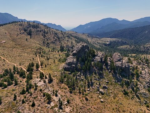 Aerial view of Walker Ranch featuring rugged rock formations, pine trees, and winding trails set against the mountainous landscape of Boulder, Colorado, United States.
