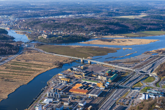 Aerial view of Bohus Fortress overlooking the Gota alv river, with industrial facilities, a bridge, and forest landscapes in Ale, Vastra Gotaland County, Sweden.