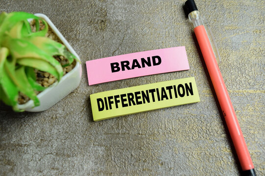 Concept of brand differentiation write on sticky notes isolated on Wooden Table. For competitive advantage unique identity market positioning