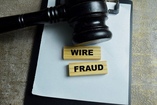 Concept of wire fraud text on wooden blocks with judge gavel. For financial crime and electronic payment fraud