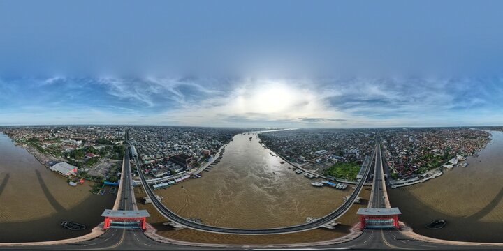 Aerial view of the Ampera Bridge spanning the Musi River with the urban landscape of Palembang in the background in Kecamatan Seberang Ulu I, Sumatera Selatan, Indonesia.