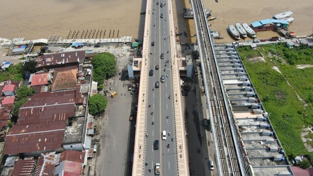 Aerial view of the Ampera Bridge with traffic and light rail transit tracks crossing the Musi River in Kecamatan Seberang Ulu I, Sumatera Selatan, Indonesia.