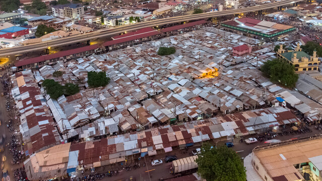 Aerial view of the bustling Tamale Central Market with its dense grid of corrugated metal roofs, narrow alleyways, and surrounding urban infrastructure in Tamale, Northern Region, Ghana.