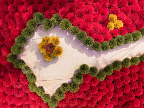 Aerial view of incense sticks drying in vibrant red, green, and yellow patterns on a sunny day in Vietnam.