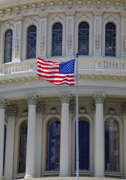 Washington, DC, USA - August 26, 2025:  us flag waving in front of US Capitol Building dome architectural details in Washington DC