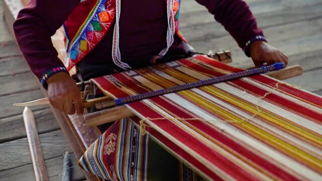 Close-up of a Peruvian man's hands knitting traditional Peruvian textile in slow motion, highlighting Andean craftsmanship, handmade weaving, cultural heritage, and artisan skills