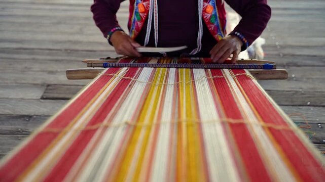 Close-up of a Peruvian man's hands knitting traditional Peruvian textile in slow motion, highlighting Andean craftsmanship, handmade weaving, cultural heritage, and artisan skills