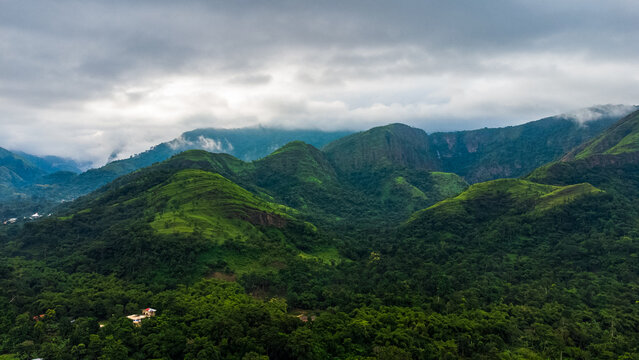 Aerial view of the lush green mountains and dense tropical forest surrounding Likpe Bakwa in the Volta Region, Ghana.