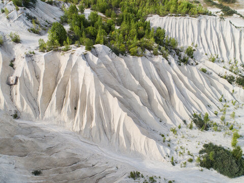 Aerial view of Rummu quarry featuring white ash hills with deep erosion gullies and patches of green trees Rummu, Harju County, Estonia.