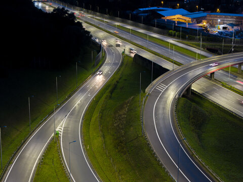 Aerial view of a highway interchange at night with illuminated roads and light trails from moving vehicles in Wieliczka, Lesser Poland Voivode, Poland.