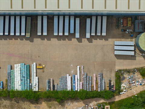 Aerial view of an industrial distribution centre with rows of parked HGV trailers and stacked shipping pallets at a warehouse facility in Doncaster, England, United Kingdom.